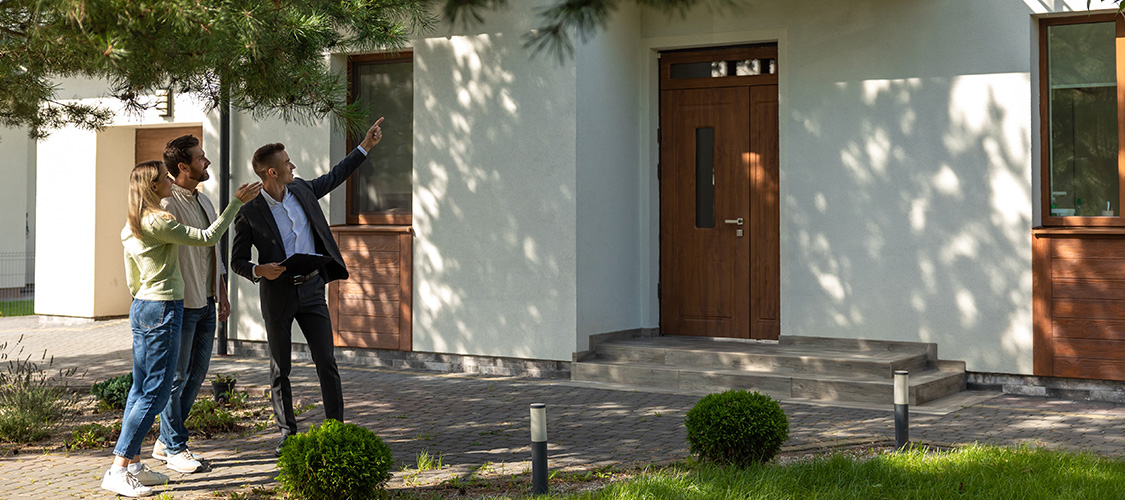 Someone approaching a home for sale during the day