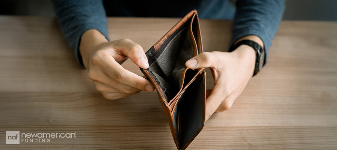 Someone opening an empty wallet.