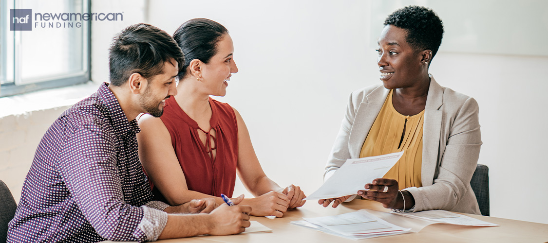A couple discussing their finances with a loan officer