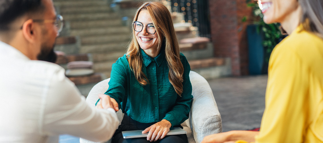 A woman shaking a man's hand.
