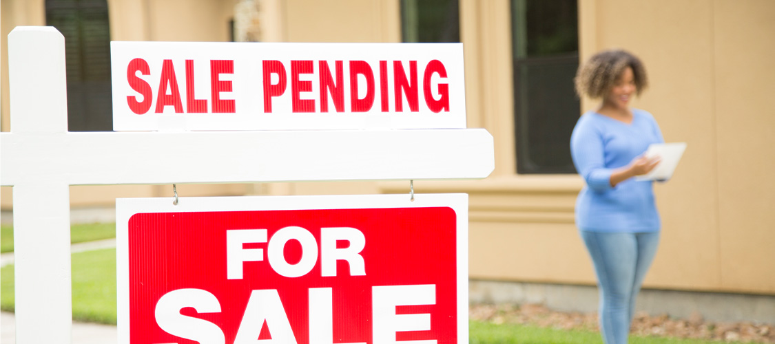 A sale pending sign in front of a home