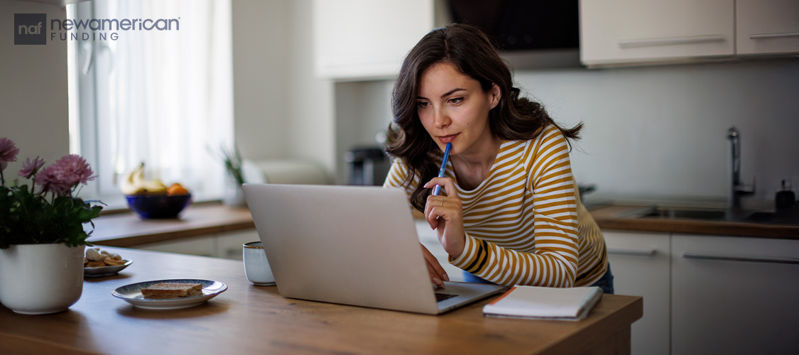 A woman looking at her laptop.