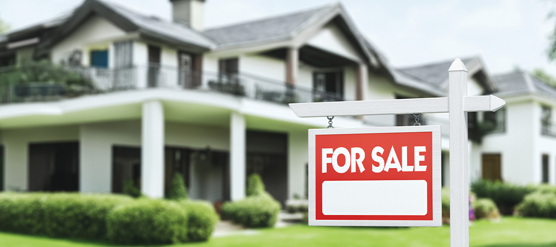 A home with a for-sale sign in front of it.