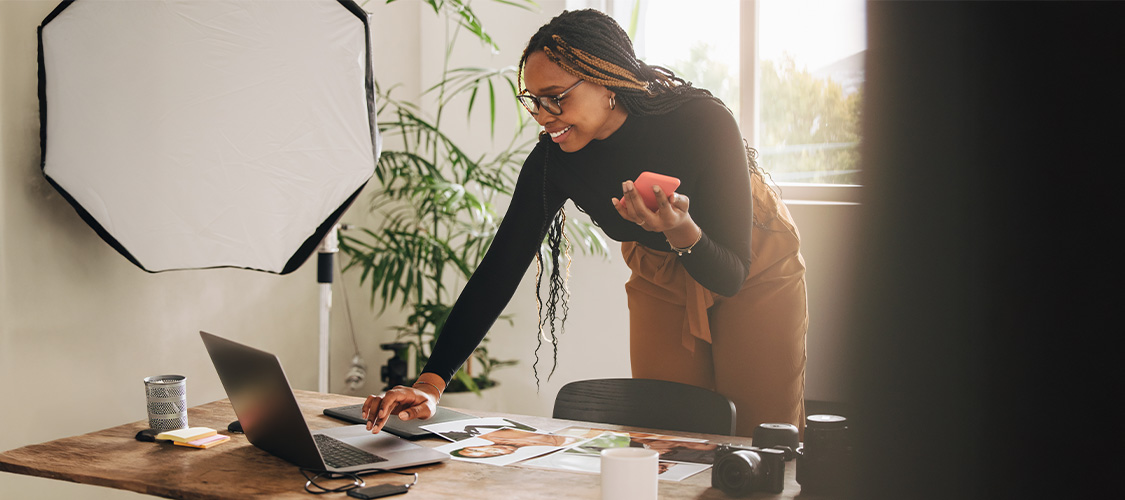 A woman standing and working on a laptop computer