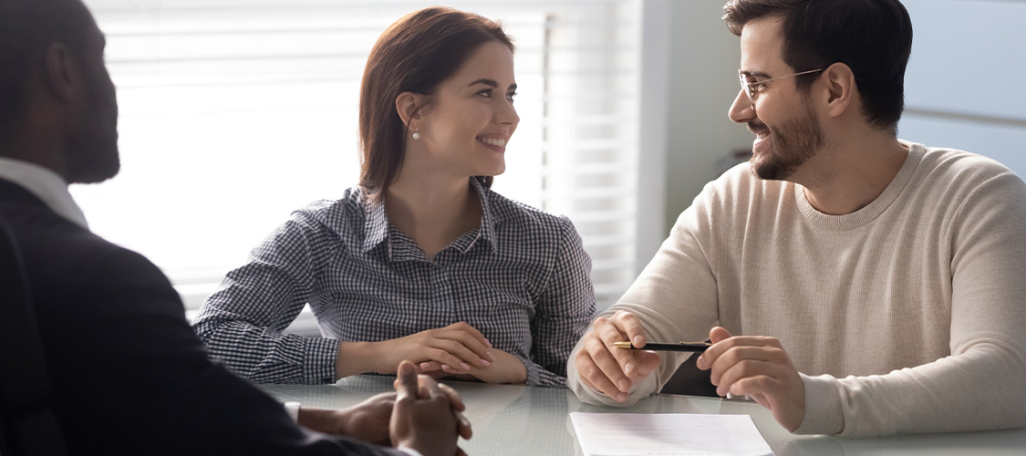 Smiling couple signing paperwork