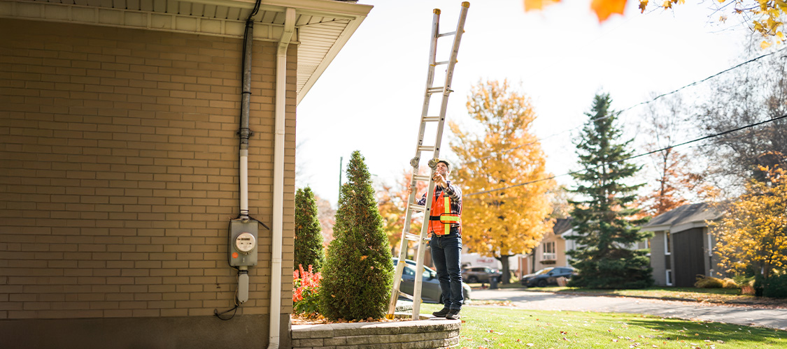 Utility worker working on a home in the fall