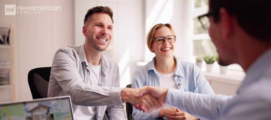 A couple shaking the hand of a loan officer.