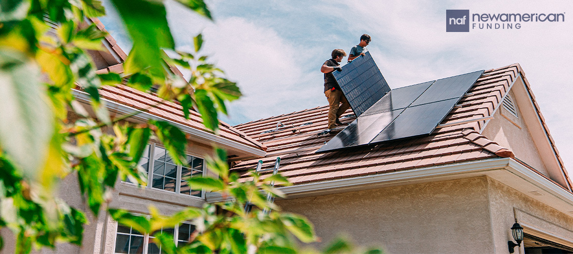 People installing solar panels on a house's roof