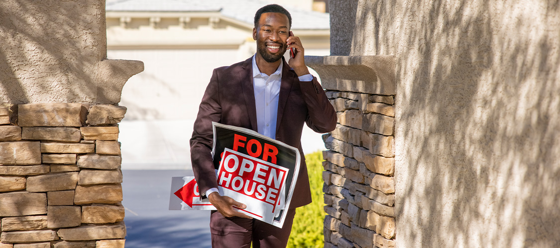 A real estate agent with a for sale sign