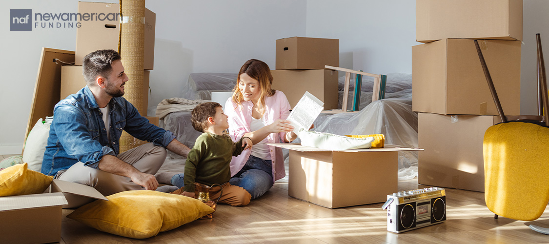 A couple and a young boy unpacking boxes.