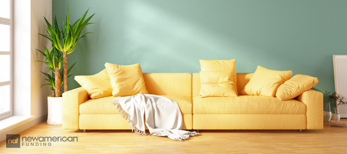 A green room with a butter yellow couch.