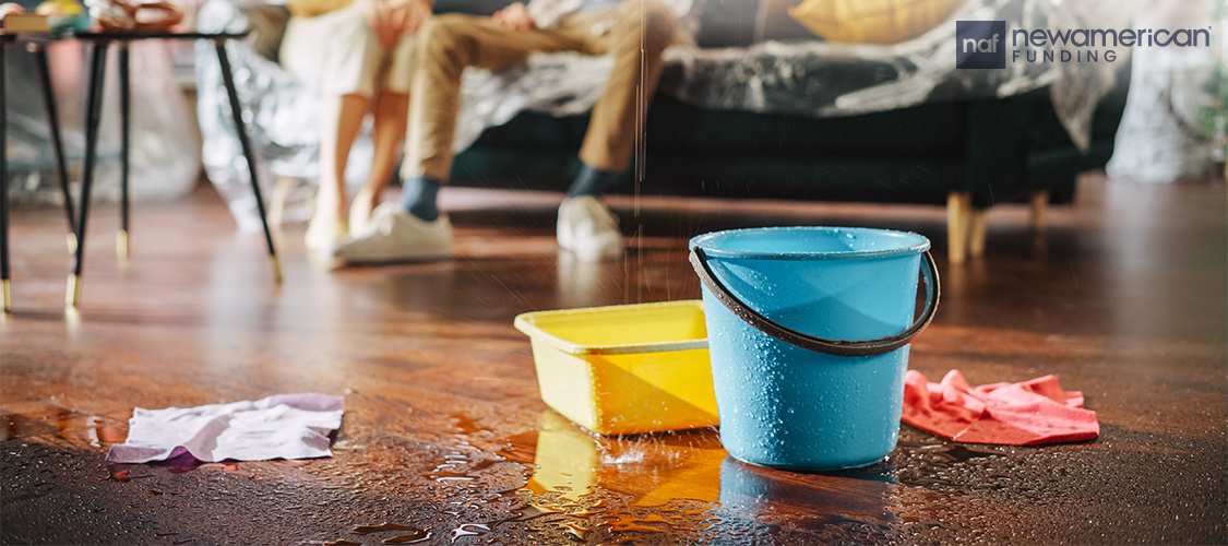 A floor with buckets catching leaking water.