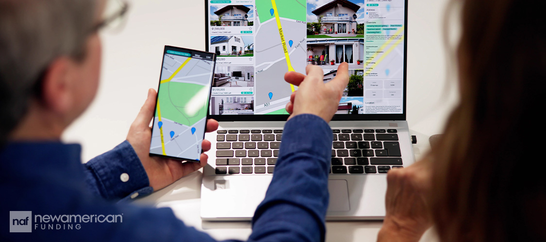 A couple looking at home listings on a cell phone and a laptop.