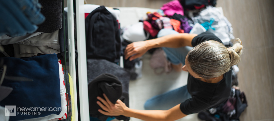 Someone sorting through closet clothes drawers.
