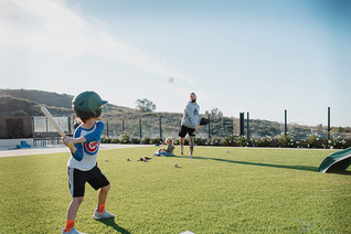 Trevor Williams pitches a wiffle ball to his son Isaac in their backyard in San Diego