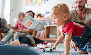 Uvajanje v vrtec – malček se v očetovi družbi igra v vrtčevskimi igračami.