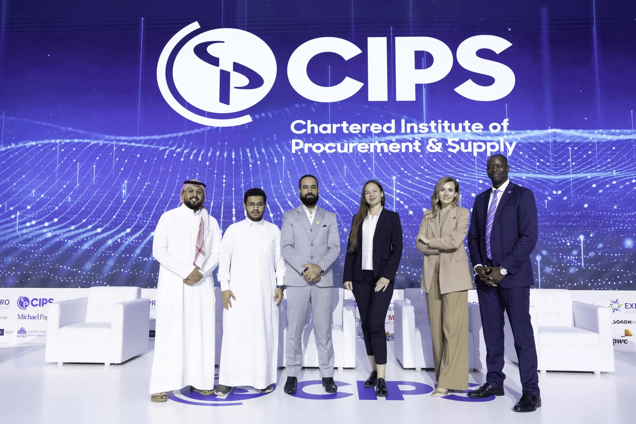 Six professionals standing on stage under a CIPS Chartered Institute of Procurement & Supply backdrop.