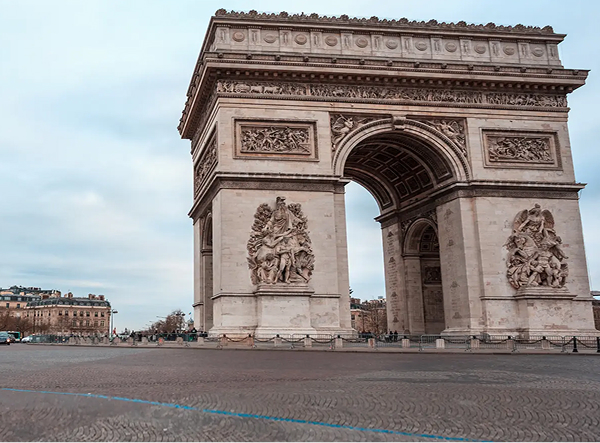 Arc de Triomphe monument in Paris, France, on a cloudy day.