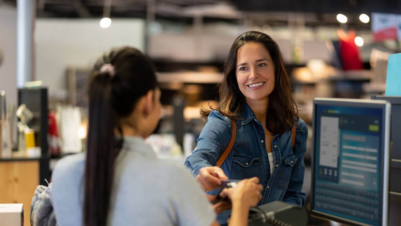 Image of a woman handing a card to an associate.