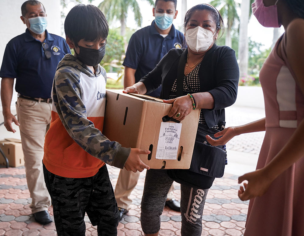 A family receives a box of fresh produce
