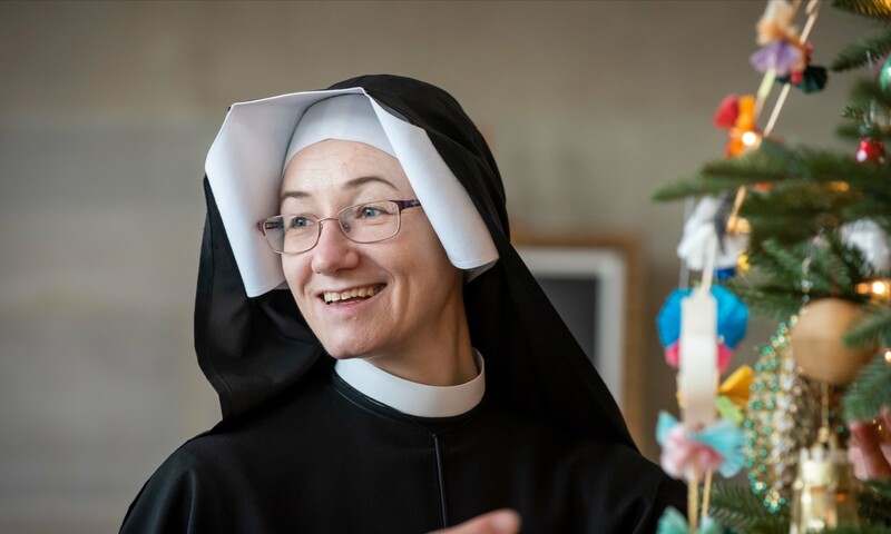 A portrait of Sister Inga Kvassayova, ISMM, standing next to a Christmas Tree.