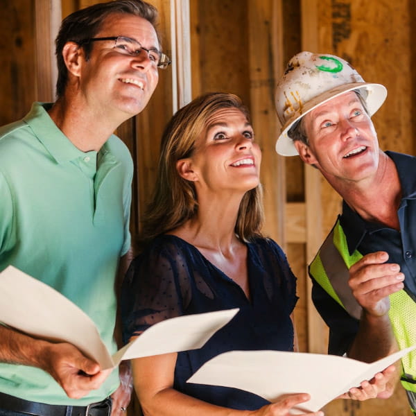 couple reviewing construction plans with contractor