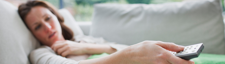 Woman who is unwell lying on couch.