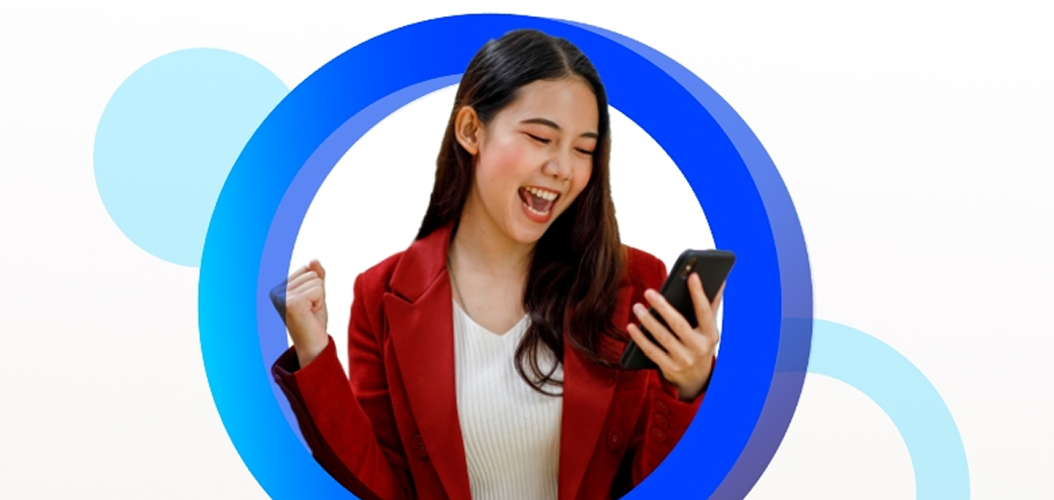 Young woman in a red jacket smiling and looking at a phone in her hand