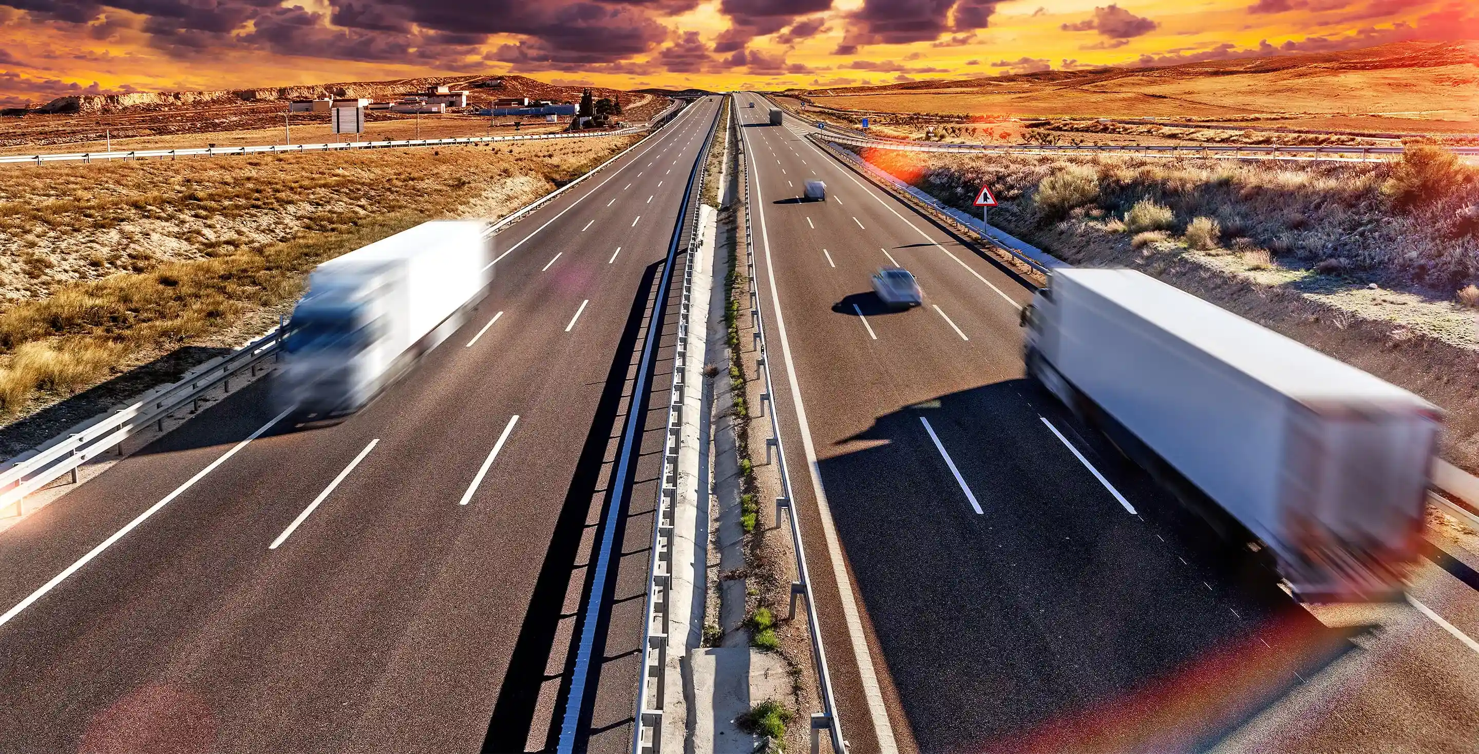 supplychain-commerce.webp Two trucks delivering goods on a highway.