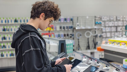 Teenager shopping for a tablet in an electronics store