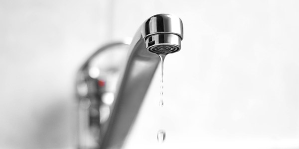 A sink faucet dripping water