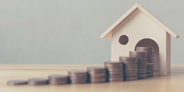 stack of coins leading to a model house