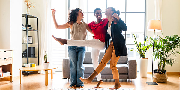 friends laughing and dancing in a home