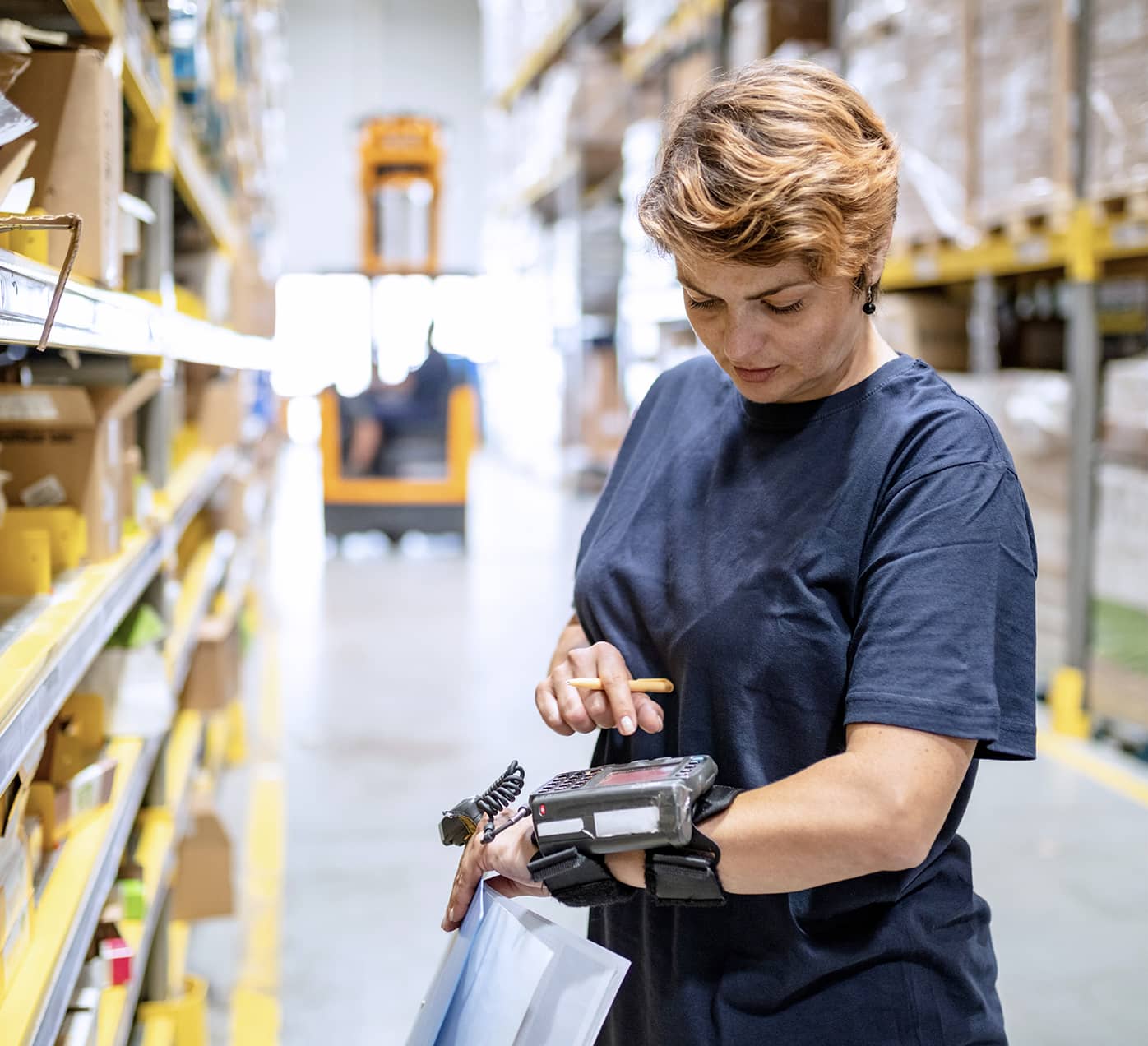 Warehouse worker using hand-operated scanner device