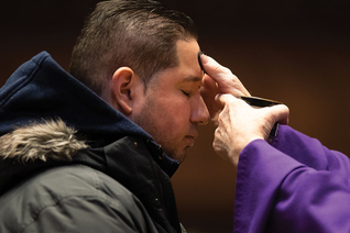 Parishioner receiving ashes on his forehead