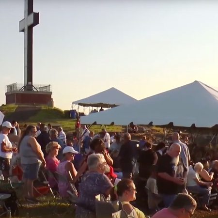 People receive holy communion from several priests during at outdoor Mass at Holy Land USA, Waterbury, CT, on August 14, 2021.