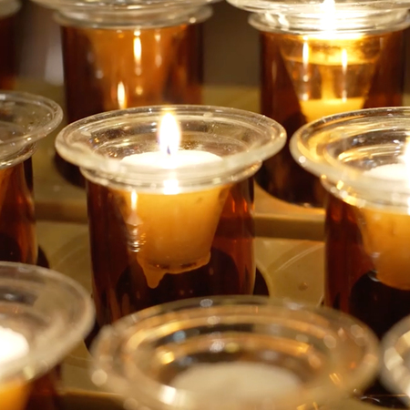 Closeup of votive candles representing the prayers of brothers and sisters in the faith. 