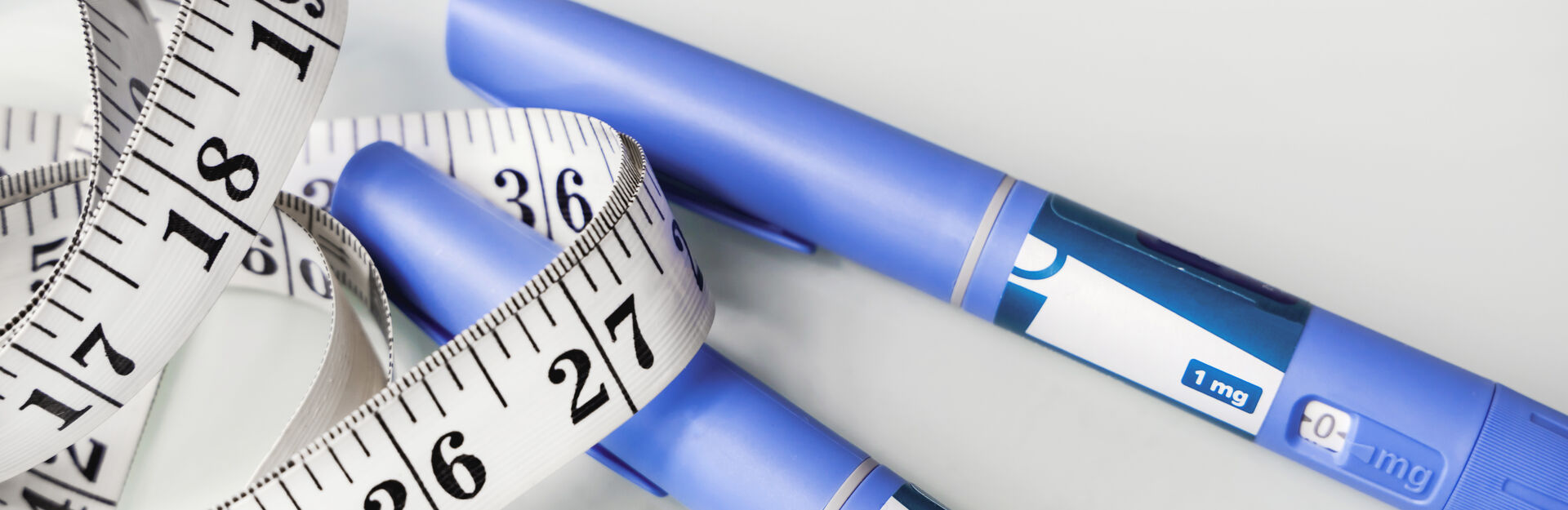 photo of scale, measuring tape and weight loss drugs to combat obesity