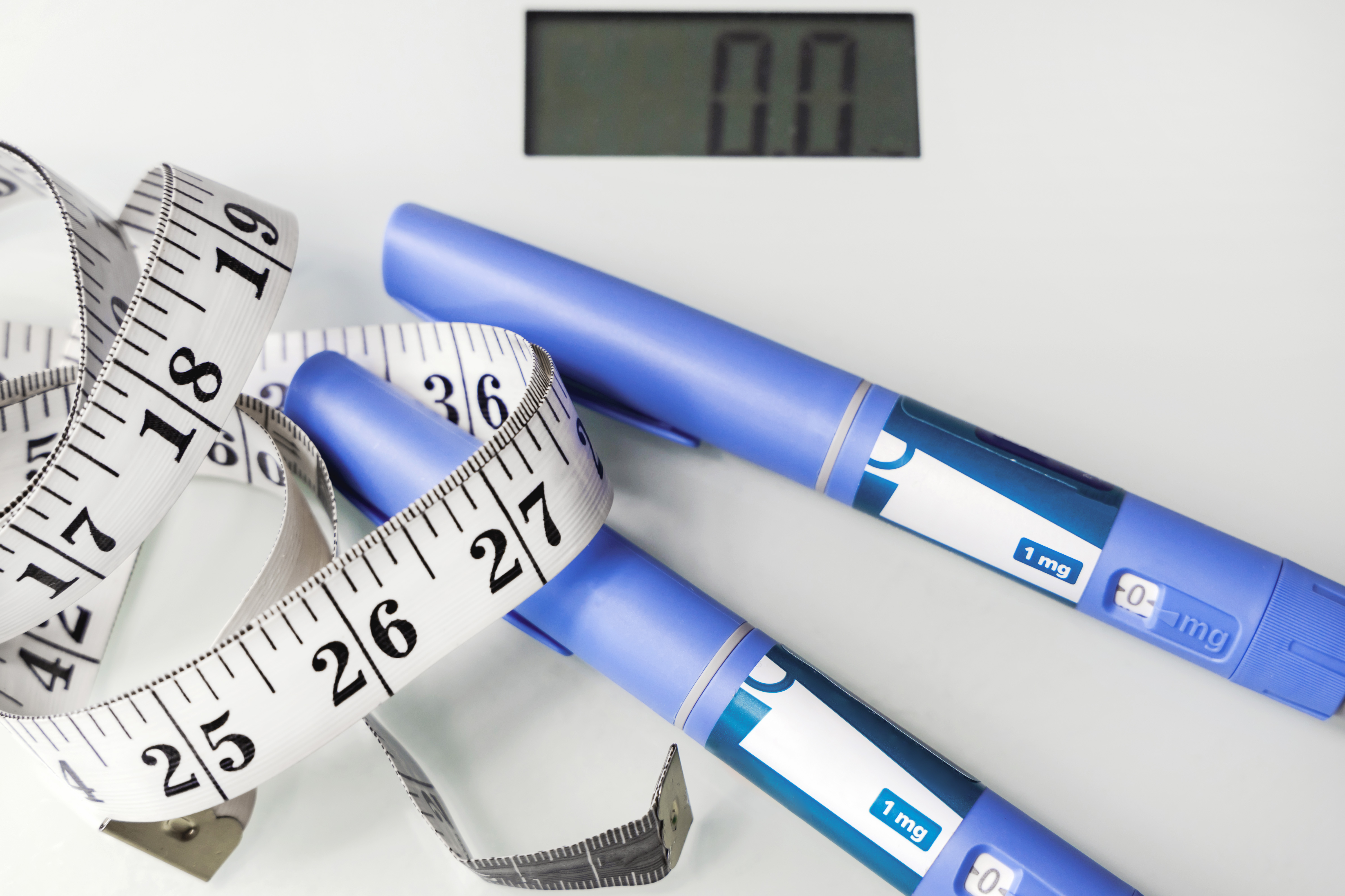 photo of scale, measuring tape and weight loss drugs to combat obesity
