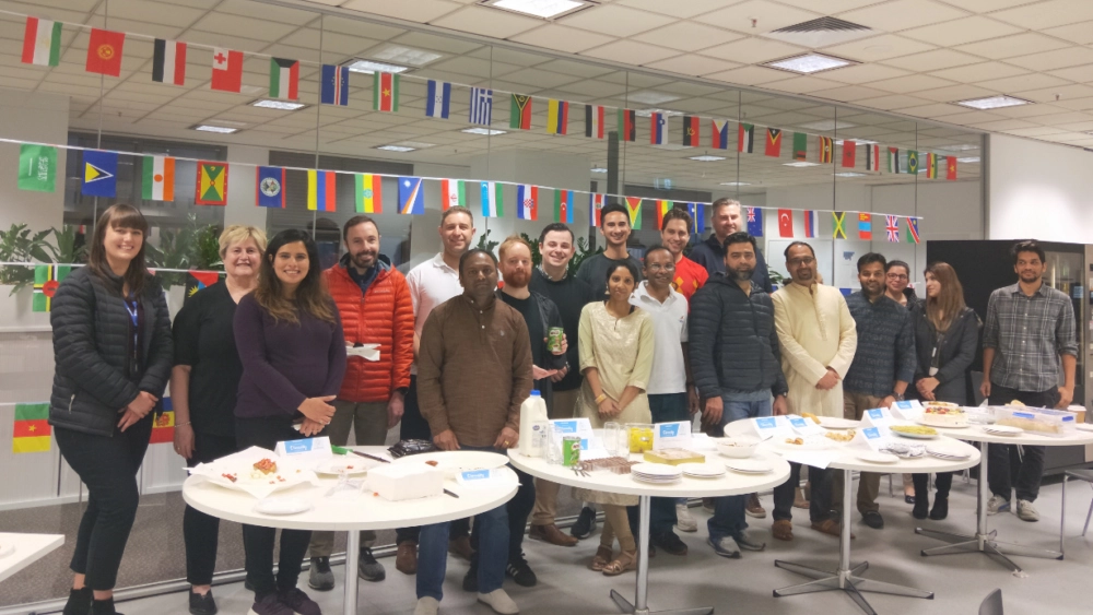 Photo of Vocus staff get together celebrating diversity. The room is decorated with flags from other countries.