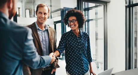 Photo of colleagues shaking hands during a meeting at work.