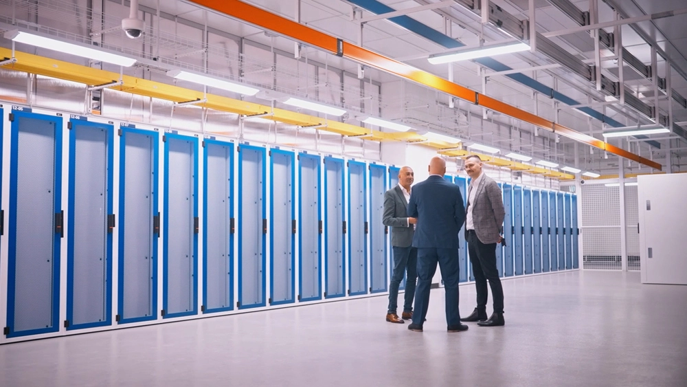 Photo of Vocus' Michael Zuchetti talking to NextDC and Comp Now representative in the Next DC server room